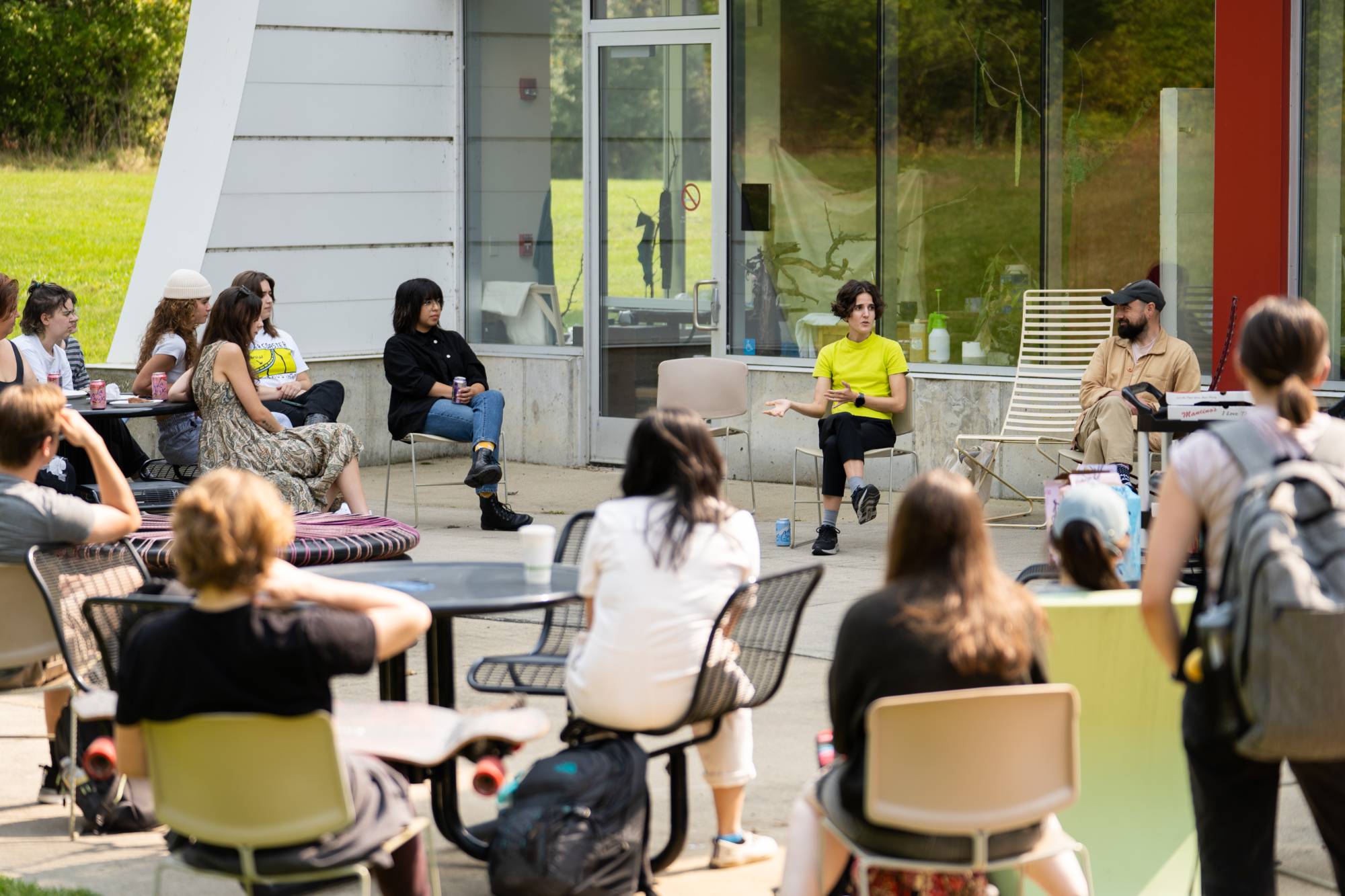 Students listening to visiting speaker in the Calder Arts Center patio